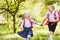 Two funny school girls with school backpacks running holding hands outdoor