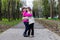 Two funny siblings sister hugging with each other while walk in park