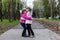 Two funny siblings sister hugging with each other while walk in park. Having fun together, positive emotions