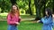 Two funny women friends are jokingly fighting among themselves on the street in the park