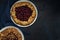 Two galettes with ripe red cherry and walnut filling on dark blue background. Homemade sweet open pie. Top view. Space for text