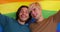 Two gay men wrapping into lgbt flag