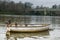 Two geese stand on a rowing boat parked in the waters of the Thames