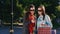 Two girl friends with shopping bags used smartphone outdoor