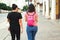 Two girl friends walking city and talking, back view. Friendship, relationship and lifestyle concept. Women travelling together