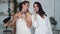 Two girl friends in white bathrobe dance, sing and dry hair with hairdryer, laugh