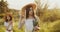 Two girl teenagers in white dresses and straw hats with flowers bouquet posing on nature background at sunny summer day