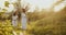 Two girl teenagers in white dresses and straw hats with flowers bouquet walking on nature at sunny summer day