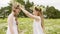 Two girl wearing floral wreath having fun on blooming meadow at summer day. Happy girl teenager playing with flower