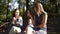 Two girlfriends with a child sit on a bench in the city Park and eat ice cream. Homosexual couple, young lesbian women