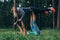 Two girlfriends doing partner yoga pose, flying warrior, on grass in forest
