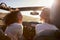 Two girlfriends driving with sunroof open look at each other