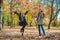 two girlfriends fooling around with yellow leaves at city park