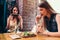 Two girlfriends having healthy lunch in cafe. Young woman taking picture of food with smartphone posting on social media