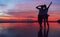 Two girlfriends hugging up and enjoying a rose/pink sunset sky on the sea beach on the Samui Island,Thailand. Calm warm countries