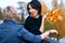 Two girlfriends talking and posing in autumn city park. Beautiful adult woman, blond and brunette