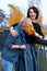 Two girlfriends talking and posing in autumn city park. Beautiful adult woman, blond and brunette