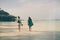 Two girlfriends walking along ocean coast morning