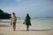 Two girlfriends walking ocean coast in morning