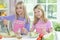 Two girls in aprons preparing fresh salad