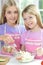 Two girls in aprons preparing fresh salad