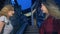 Two girls, Asian and Caucasian, chat in the evening on the street of the modern city. standing on the escalator.