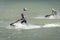 Two girls athletes boldly rush along the sea waves on aquabike