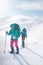 two girls with a backpack and snowshoes walk in the snow during a snow storm