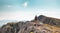 two girls with backpacks walk along a mountain path