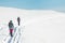 two girls with backpacks walk along a path in the winter mountains. hiking in the mountains