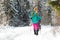 two girls with backpacks walk along a path in the winter mountains. hiking in the mountains