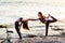 Two girls on the beach doing yoga at sunset. Lima Peru.