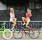 Two girls on a bicycles. Outdoor fashion portrait