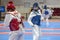 Two girls in blue and red Taekwondo equipment fight in doyang in Taekwondo competitions