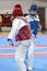Two girls in blue and red Taekwondo equipment fight in doyang in Taekwondo competitions