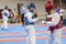 Two girls in blue and red Taekwondo equipment fight in doyang in Taekwondo competitions