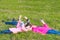 Two girls and a boy lie on the grass and play spinner