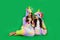 Two girls in bright costumes, eat lots candy canes on a green background Space for text. holiday concept