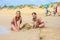 Two girls build sand castles on the seashore, bicycles stand in the background