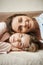 Two girls with close relationship, feeling like sisters. Vertical shot of good-looking women lying on sofa and smiling