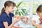 Two girls collect puzzles at the table and eat carrots