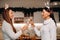 Two girls in a cozy home environment with champagne in their hands at Christmas. Smiling girls drink champagne on a festive