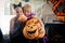 Two girls disguised as a tiger and as a witch are holding three pumpkins