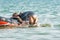 Two girls dive from an inflatable boat into the sea