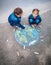 Two girls drawing Earth with chalks
