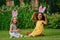 two girls during Easter egg hunt and putting Easter eggs in baskets