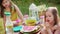 Two girls eat strawberries on a summer picnic