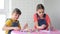 Two girls enthusiastically play a board game at home