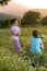 Two girls flowers field at sunset