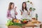 Two girls friends preparing dinner in a kitchen concept cooking, culinary, healthy lifestyle.